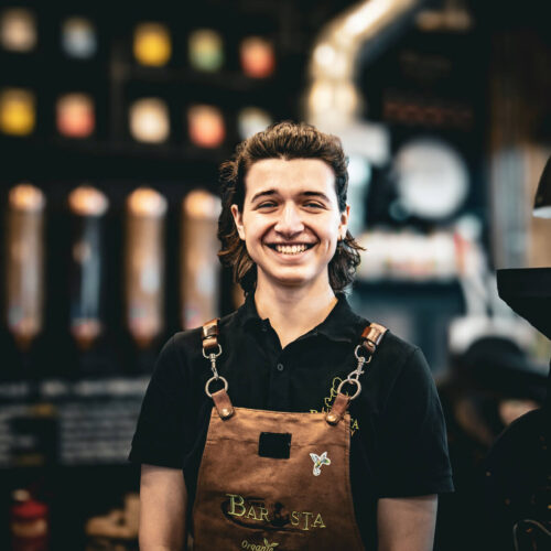 Sasha the barista at Little Barista – preparing coffee behind the counter in a specialty coffee shop